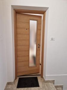 eine Holztür im Flur mit Spiegel in der Unterkunft Appartamento SOMEDA in Moena
