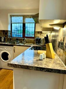 a kitchen with a counter top with a washing machine at 3br House Ossett-Wakefield, Free Parking 3 cars Wi Fi Long stays in Wakefield