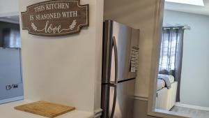a refrigerator in a kitchen with a sign on the wall at Robin's Nest Savannah in Savannah