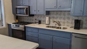 a kitchen with blue cabinets and a sink at Robin's Nest Savannah in Savannah