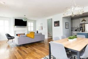 a living room with a couch and a dining room table at The Lillian House - Steps to Five Points in Nashville