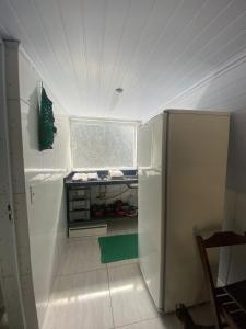 Cette chambre comprend une petite cuisine équipée d'un réfrigérateur. dans l'établissement Chales Guarau, à Peruíbe