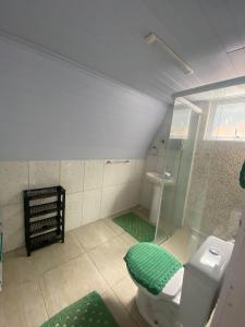 La salle de bains est pourvue d'une douche en verre et de toilettes. dans l'établissement Chales Guarau, à Peruíbe