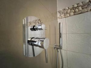 a shower with a glass door with rocks on the wall at Casa T'Isabel - Fisherman's Beach - 2 bedrooms in Albufeira