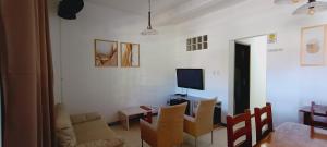 een woonkamer met een tafel en stoelen en een televisie bij Hostel Lar dos Idosos e Adultos in Salvador