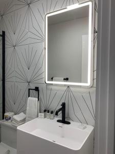 uma casa de banho com um lavatório branco e um espelho. em Chalet 239-Boutique Hotel em West Dover