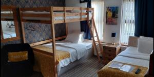 a bedroom with two bunk beds and a ladder at Carnately Lodge in Ballycastle