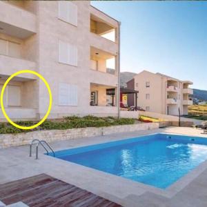 a house with a swimming pool in front of a building at Sea view & pool studio by Pag tours in Pag