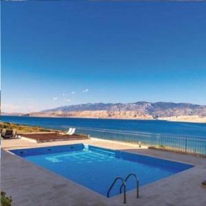 a large swimming pool next to a large body of water at Sea view & pool studio by Pag tours in Pag