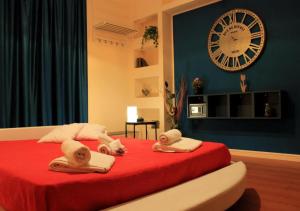 dois cães numa cama com um grande relógio na parede em Bracco Rooms & Suites em Matera