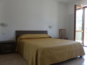 sypialnia z łóżkiem z żółtym kocem i oknem w obiekcie Casa Marisa w mieście Malcesine