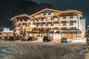 um grande edifício com carros estacionados em frente em Hotel Olympia em Ischgl