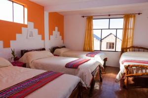 a group of four beds in a room with a window at Hostal Margarita Isla del Sol Norte comunidad Challapampa in Comunidad Challapampa
