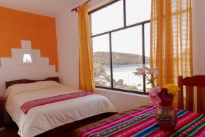 ein Schlafzimmer mit einem Bett und einem großen Fenster in der Unterkunft Hostal Margarita Isla del Sol Norte comunidad Challapampa in Comunidad Challapampa
