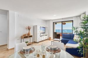 ein Wohnzimmer mit einem Tisch und einem blauen Sofa in der Unterkunft Sunrise & Sunset Unique Experience Sea Views Parking Pool Mijas Costa & Fuengirola in Mijas Costa