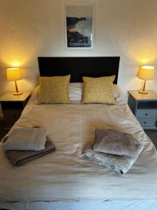 uma cama grande com duas almofadas com duas lâmpadas em The Hay Loft em Helston