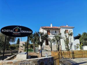 a sign in front of a house with a building at Kostis Orange Resort in Volos