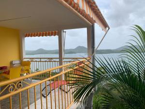 a balcony of a house with a view of the water at Gite Oiseau du Paradis in Le Marin
