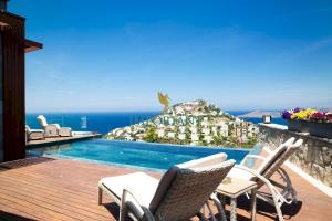una terrazza con sedie e una piscina di Villa Calista by Important Group Travel a Yalıkavak