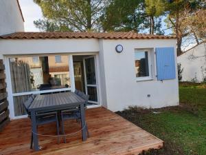 a picnic table on a deck in front of a house at la belle cascade in Dolus-d'Oléron