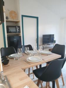 a wooden table with chairs and wine glasses on it at la belle cascade in Dolus-d'Oléron +3 photos