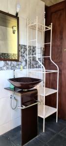 a bathroom with a sink and a shelf at Nature love Negombo in Kochchikade