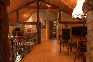 a room with a wooden hallway with a table and a television at Casa de Artes Guest House in Balchik
