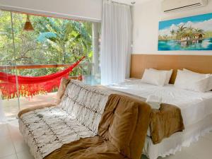 um quarto com uma cama e uma grande janela em Vários Apartamentos no villas maceio em Maceió