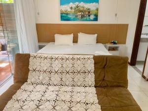 um quarto com uma cama com um cobertor em Vários Apartamentos no villas maceio em Maceió