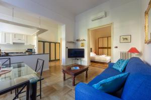 ein Wohnzimmer mit einem blauen Sofa und einem Tisch in der Unterkunft Colonna Apartment in Florenz