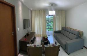 a living room with a couch and a table at Vários Apartamentos no villas maceio in Maceió