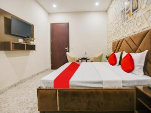 um quarto com uma cama grande e almofadas vermelhas em Super OYO Silver Sky em Ludhiana