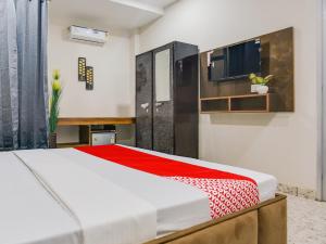 盧迪亞納的住宿－Super OYO Silver Sky，一间卧室配有一张带红色毯子的床