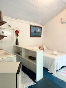 een witte kamer met een bureau en een bed bij Chales do Oliveira in Porto Seguro