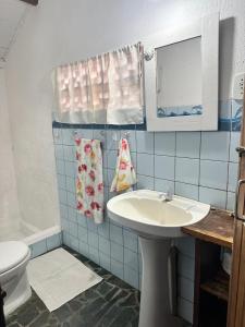 uma casa de banho com um lavatório, um WC e um espelho. em Chales do Oliveira em Porto Seguro