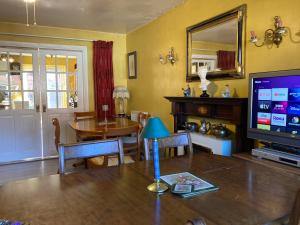 a living room with a table and a television and a dining room at Jacks Court B4c in Stalybridge