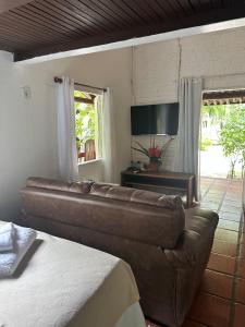 Chales do Oliveira في بورتو سيغورو: غرفة معيشة مع أريكة وطاولة