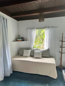 a bedroom with a large bed with a window at Chales do Oliveira in Porto Seguro