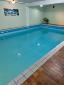 una gran piscina de agua azul en una habitación en Landhotel Neding en Hauenstein