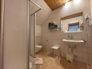 y baño con ducha, lavabo y aseo. en Gasthof Thurnerhof, en Feld am See