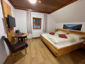 Dormitorio con cama, escritorio y TV en Gasthof Thurnerhof, en Feld am See