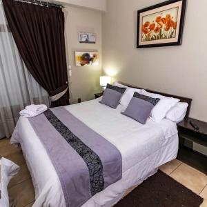 Oriente Hostal في تالكا: غرفة نوم بسرير كبير في غرفة