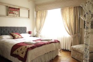 una camera da letto con un letto e una grande finestra di Oriente Hostal a Talca