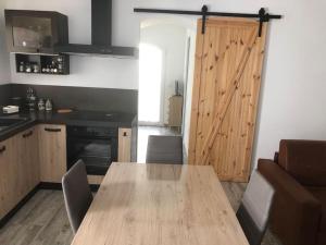 cocina con mesa de madera y puerta de madera en Il nido vicino Castel di Sangro ed Alfedena, en Montenero Val Cocchiara