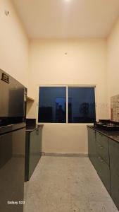 an empty kitchen with a large window in a room at LDS Homestay in Rāmnagar