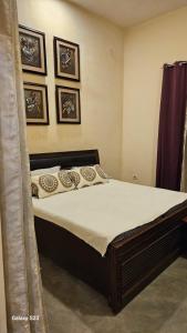 um quarto com uma cama num quarto com fotografias na parede em LDS Homestay em Ramnagar