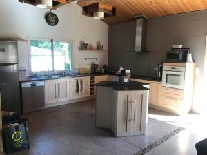 a large kitchen with white cabinets and a counter at LA LANDAISE in Sainte-Eulalie-en-Born