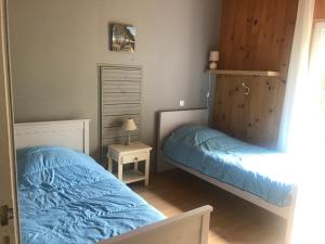 two beds in a bedroom with blue comforter at LA LANDAISE in Sainte-Eulalie-en-Born +23 photos