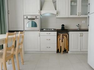 a kitchen with white cabinets and a table and chairs at Ionesco Apartments in Cluj-Napoca