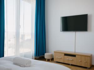 a bedroom with a bed and a television on a dresser at Ionesco Apartments in Cluj-Napoca